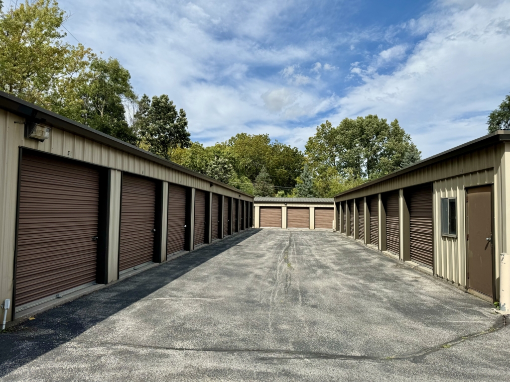 Two rows of storage lockers with beige walls, dark brown doors and a darker brown roofing